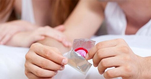 Phòng chống mụn rộp sinh dục bằng cách đeo bao cao su khi quan hệ